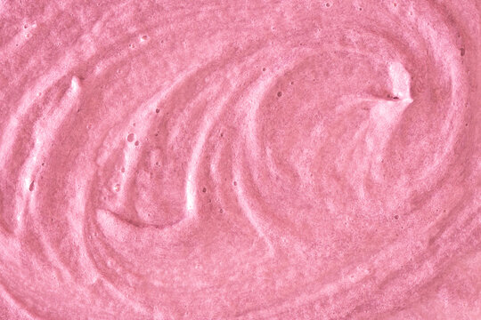 Pink cream texture. The surface of berry yogurt and a smoothie of whipped cream. Background texture of masks and scrubs for face and body. Pearlescent silver surface of pink foam.