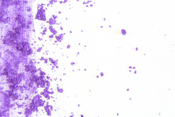 Fototapeta na wymiar Colored powder on a white background. Purple eyeshadows are scattered and smeared, makeup. Holi Colorful festival of colored paints powders and dust. A holiday of bright colors to entertain people.