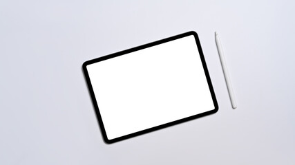 Flat lay digital tablet with empty display and stylus pen on white background