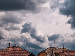 Dark ominous stormy clouds over house rooftops
