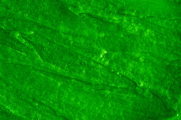 Smears of liquid green gel texture background. Smeared oil paint with pearly shine. Cream scrub to cleanse the skin of the face and body. Spa treatments, skin care.