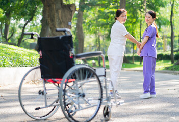 Asian female nurse taking care of a middle-aged female patient in the park