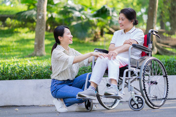 Young Asian daughter taking care of her disabled mother