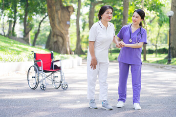 Asian female nurse taking care of a middle-aged female patient in the park