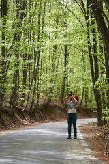 Travel photographer lady shooting in a forest