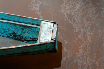 Detail of a wooden canoe on a murky river