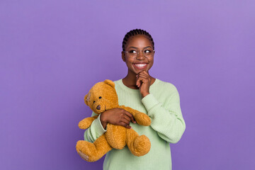 Photo of cheerful cunning young female look blank space happy to have a teddy bear isolated on...