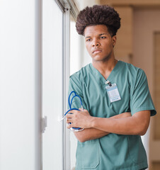 Portrait male doctor holds stethoscope seriously thinking, pondering. Thoughtful young African...