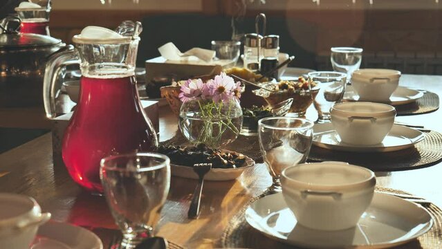 A beautiful evening table with hot dishes in the sunshine.