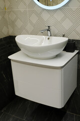 White ceramic sink on a hanging pedestal