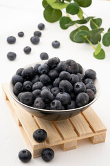 fresh, ripe, sweet blueberries, freshly picked berries inside a bowl on a small wooden pallet
