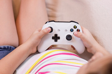 Closeup little girl hands with joystick play video game. © Aleksei