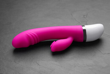 Pink vaginal vibrator on black background. Sex toy