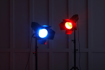 Fototapeta na wymiar Bright red and blue spotlights near wall in dark room