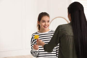 Mother giving condom to her teenage daughter at home. Sex education concept