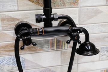 Black stylish shower faucet close-up in the bathroom interior