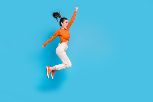 Full size profile side image of cheerful ecstatic girl look empty space win prize lottery isolated on blue color background