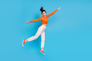 Fototapeta na wymiar Full size profile side image of excited cheerful playful female have fun jumping isolated on blue color background