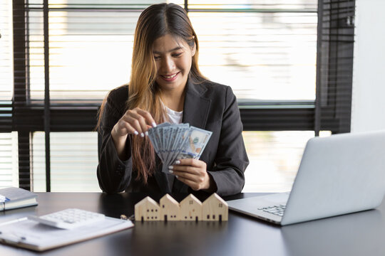 Real estate agent businesswoman counting cash, deposit or commission on real estate sales.