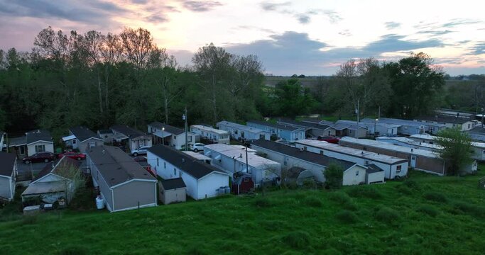 Mobile home park during spring sunset. Trailer mobile home housing in USA. American life in rural Pennsylvania. Poverty in America theme. Aerial rotation around low income housing.