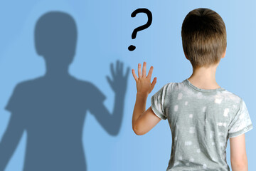 child 8-10 years old in gray t-shirt extended his hand to his shadow, concept imaginary friend,...