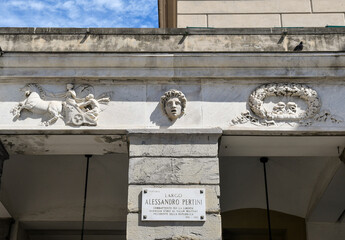 Detail of the façade of the historic Carlo Felice Theatre (1828) with the street sign of Largo...