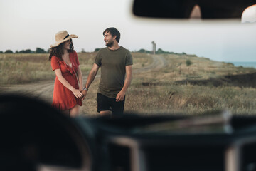 View Through Front Window of Car, Young Couple Man and Woman Having Fun Time Together Outdoors Near the Sea