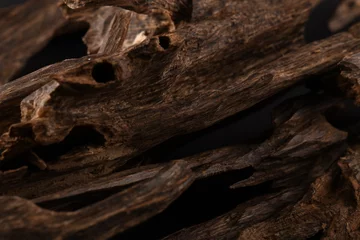 Fototapeten Close UpShot Of Sticks Of oudh On Black Background The Incense Chips Used By Burning It Or For Arabian Oud Oils Or Bakhoor  © mohamed
