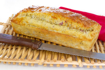 savory cake with whole ham on a basket on a white background