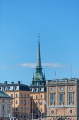 Facades of buildings and the castle in the island Gamla Stan and the spire of the german church a sunny day in Stockholm