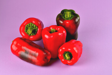 red and green sweet bell peppers on a purple background, fresh juicy vegetables on a colored background, selective focus