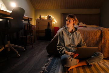 White girl with tunnel rings using laptop while sitting on floor