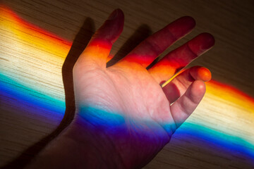 Rainbow light as diffraction on a palm, creativity concept picture