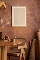 Stylish boho vintage dining room interior with poster mock up. Round table with rattan armchair,...