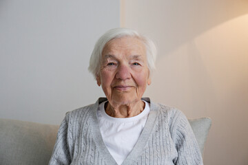 Portrait of elderly lady alone at home. Senior woman 86 years of age in her apartment. Background,...