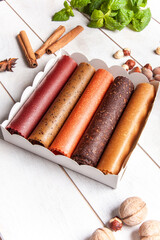 Fruit pastille of different flavors in a gift box and frash fruit, nuts, spices