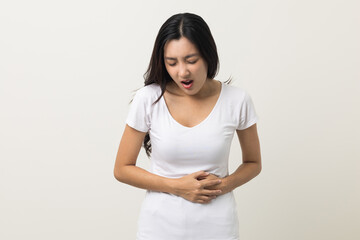 A woman had a stomach ache and gastritis. She put her hand on her stomach and squeezed it to relax and soothe. She is 25 years old and has menstrual cramps. Shot on isolated white background.