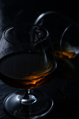 Two cognac glasses on a dark background