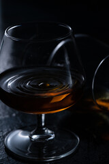 Two cognac glasses on a dark background