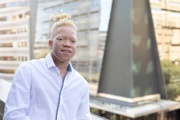 Portrait of african american albino mid adult businessman standing in office balcony