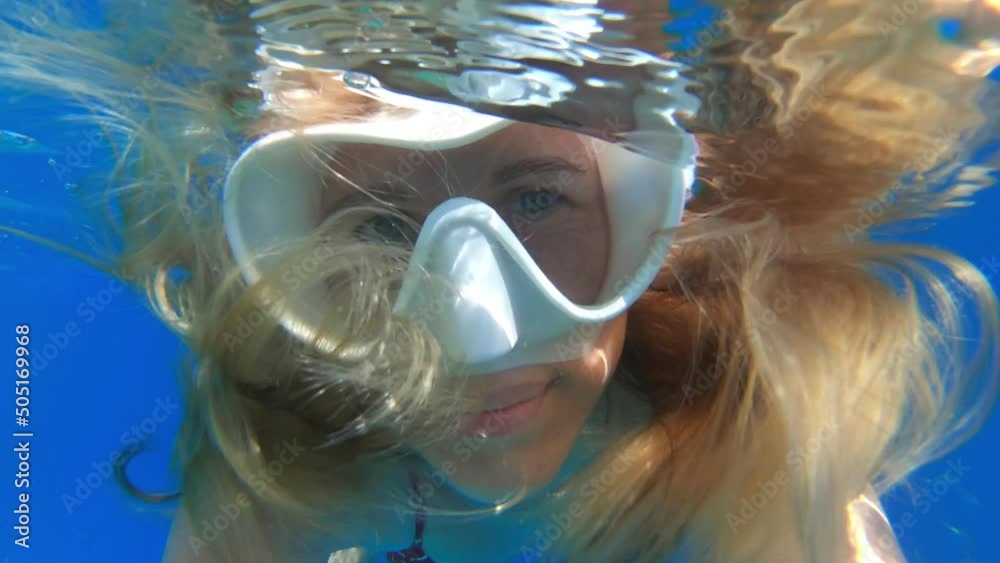 Sticker Woman with mask swims in the sea and looks into the camera