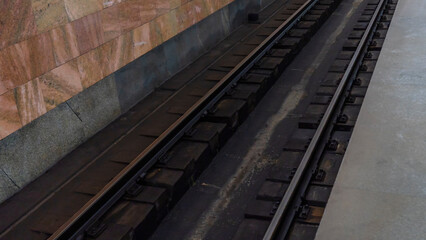 Fototapeta na wymiar Subway station view on rails. Railroad track in metro. The most convenient urban public transport.