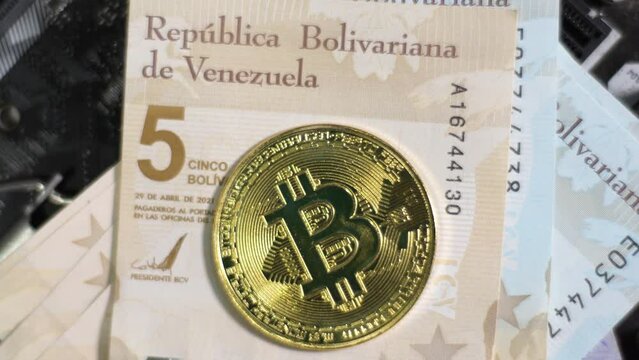 Bitcoin BTC and Bolivar digital venezolano bills on circuit board. Exchange platforms trade concept