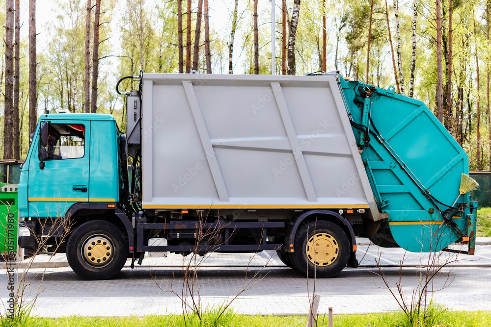 Poster A garbage truck picks up garbage in a residential area. Loading mussar in containers into the car. Separate collection and disposal of garbage. Garbage collection vehicle.
