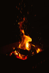burning firewood in the brazier at night, flames of fire in the dark