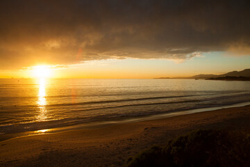 Winter sunset with golden light under heavy storm clouds. Looking out to the Pacific ocean near Ventura, California, USA