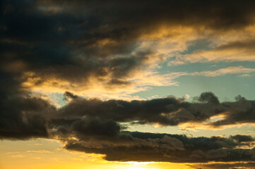 Fototapeta na wymiar Sunset in springtime with golden light and stormy looking stratocumulus clouds. Kildare, Ireland