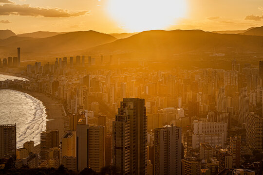Summer sunset, with golden light through the dusty haze of high-rese apartments and hotels in Benidorm, Spain