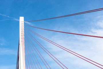 A large cable-stayed bridge on the German motorway over the river Rhine, set against a blue sky.