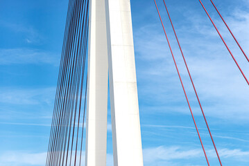 A large cable-stayed bridge on the German motorway over the river Rhine, set against a blue sky.